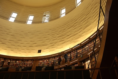 Visitors reading and discussing diverse religious books in a bright, welcoming library space.