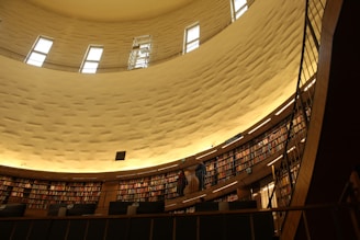 Visitors reading and discussing diverse religious books in a bright, welcoming library space.