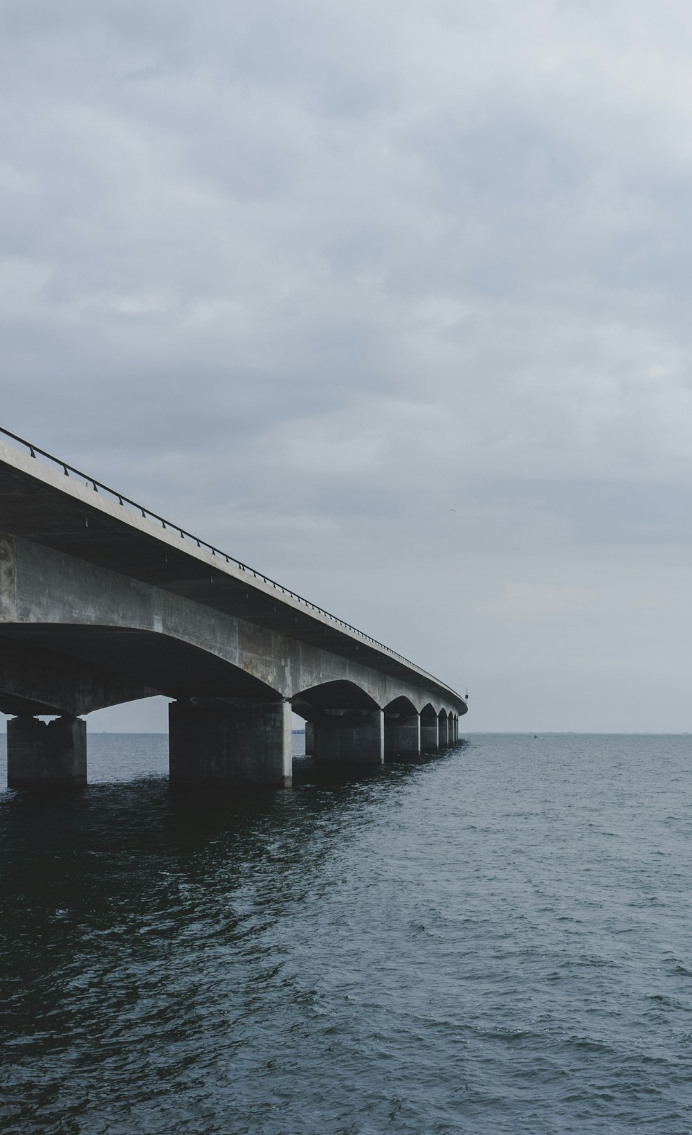 gray concrete bridge under cloudy sky