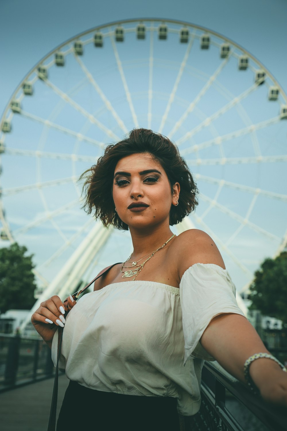 a woman standing in front of a ferris wheel