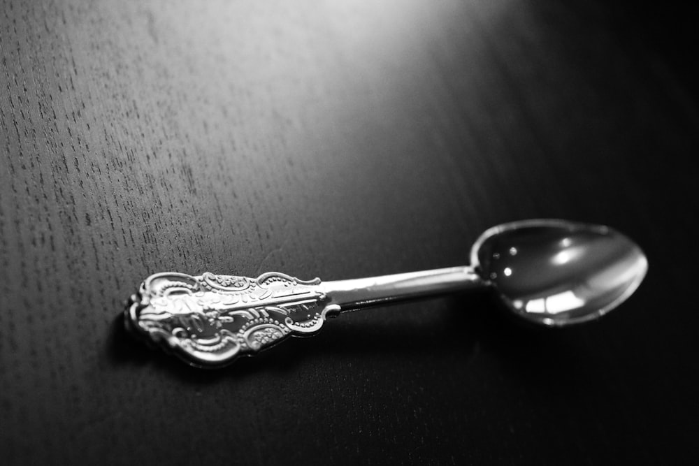 silver spoon on black surface