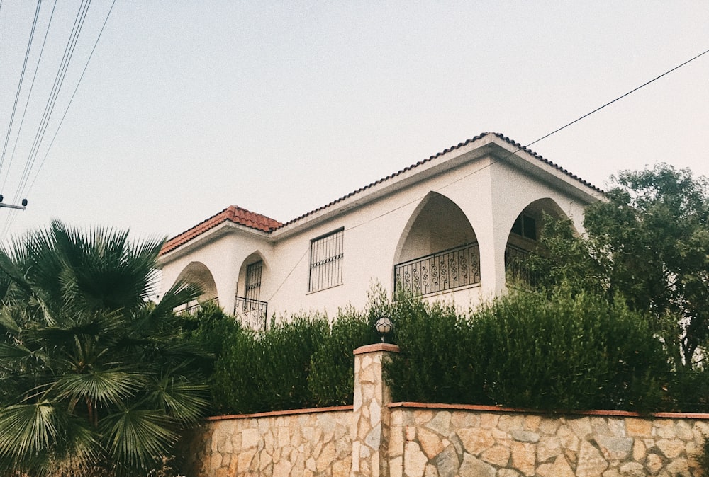 white concrete house beside green trees at daytime