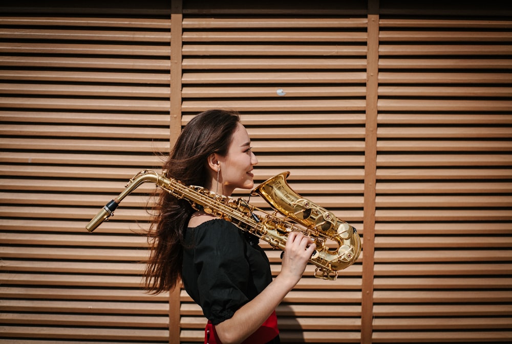 Mujer caminando y sosteniendo el saxofón