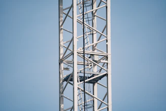 Close-up of a sturdy scissor lift platform with safety rails, set against a clear blue sky.