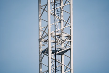 Close-up of a sturdy scissor lift platform with safety rails, set against a clear blue sky.