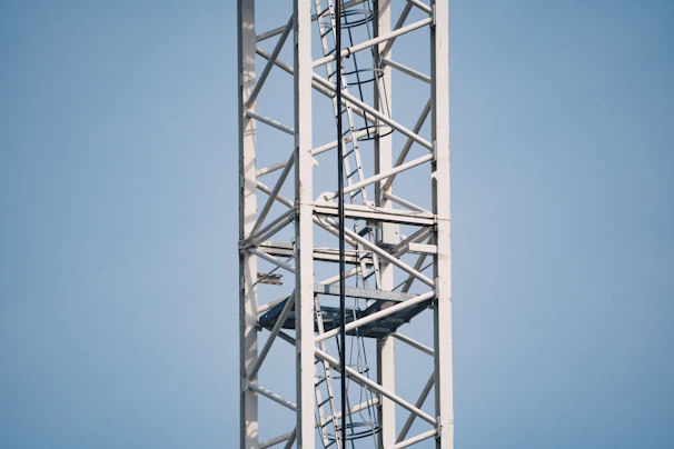 Modern aerial work platform in operation against a clear blue sky.