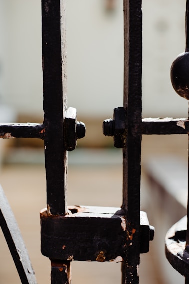 Close-up of a stainless steel gate with intricate welding details shining under natural light.