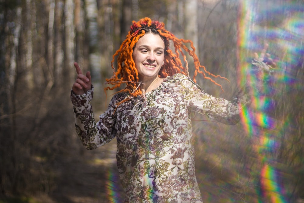 a woman with red hair is smiling and waving