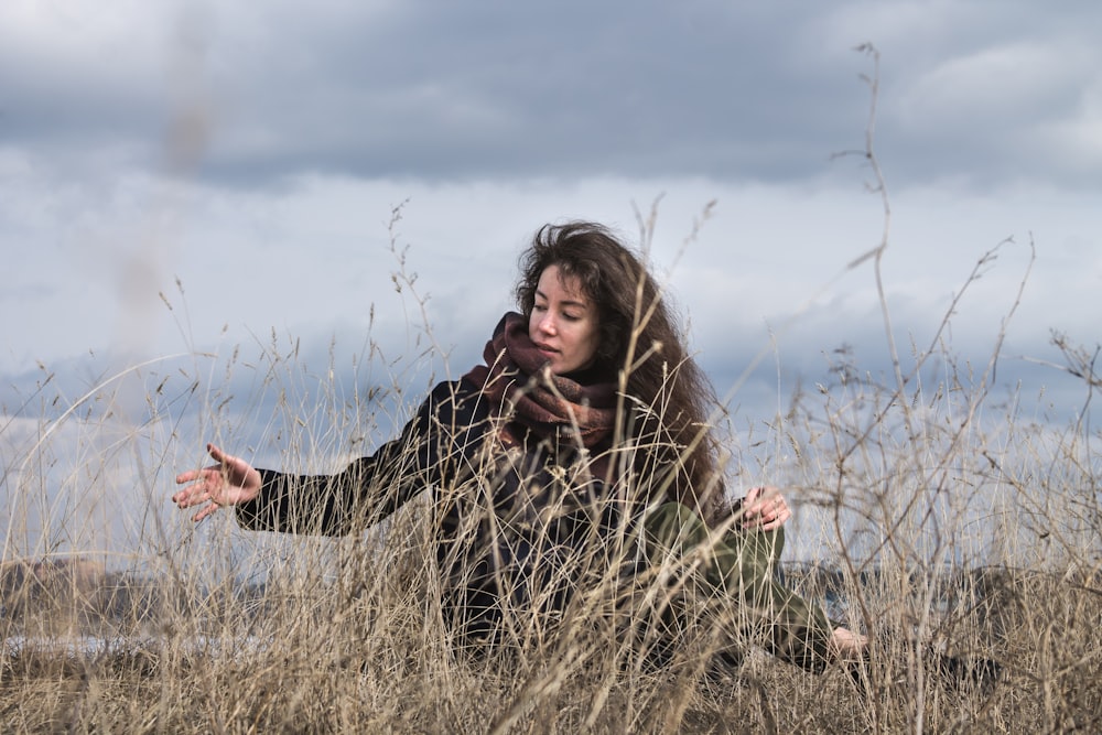 woman on grass field under cloudy sky