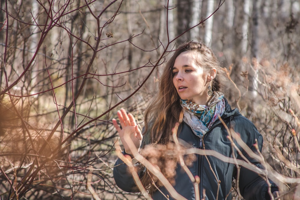 a woman standing in a field with her hands in the air