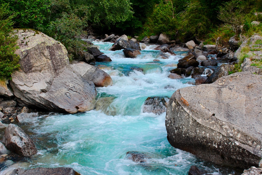 body of water beside rocks at daytime close-up photography