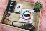 An elegant flat lay of affirmation cards and a spiritual planner on a dark, textured surface with gold highlights.