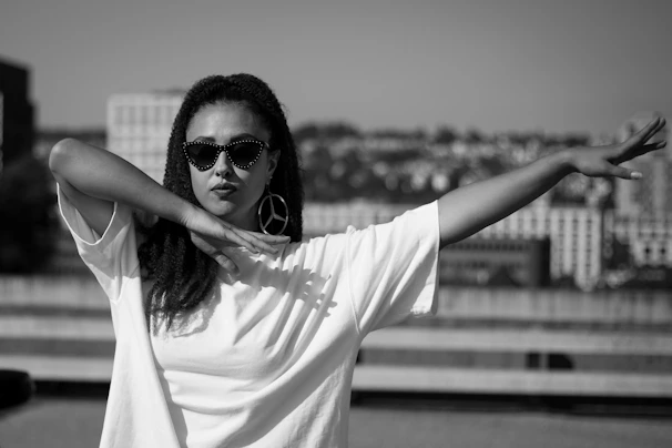 Fashion-forward model posing outdoors wearing oversized hoop earrings and a chic monochrome outfit.