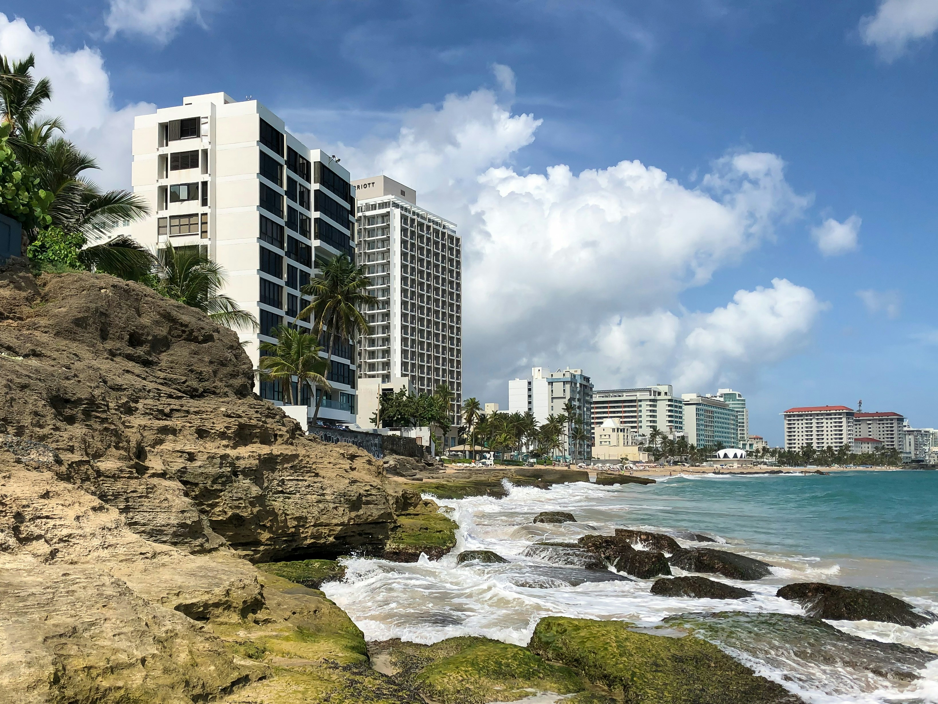 white and black concrete buildings under blue sky at daytime