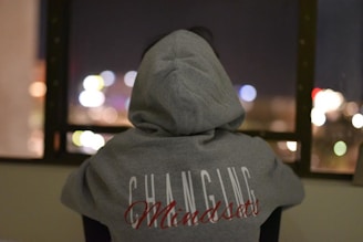 person wearing gray and red hooded jacket facing back
