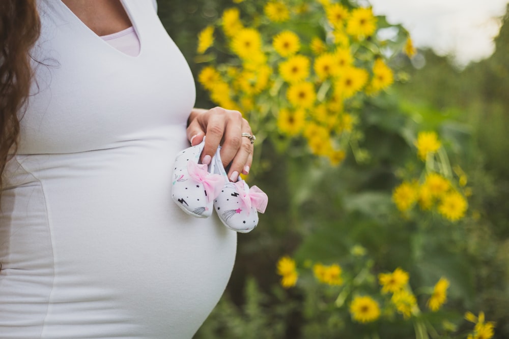 pregnant woman holding shoes