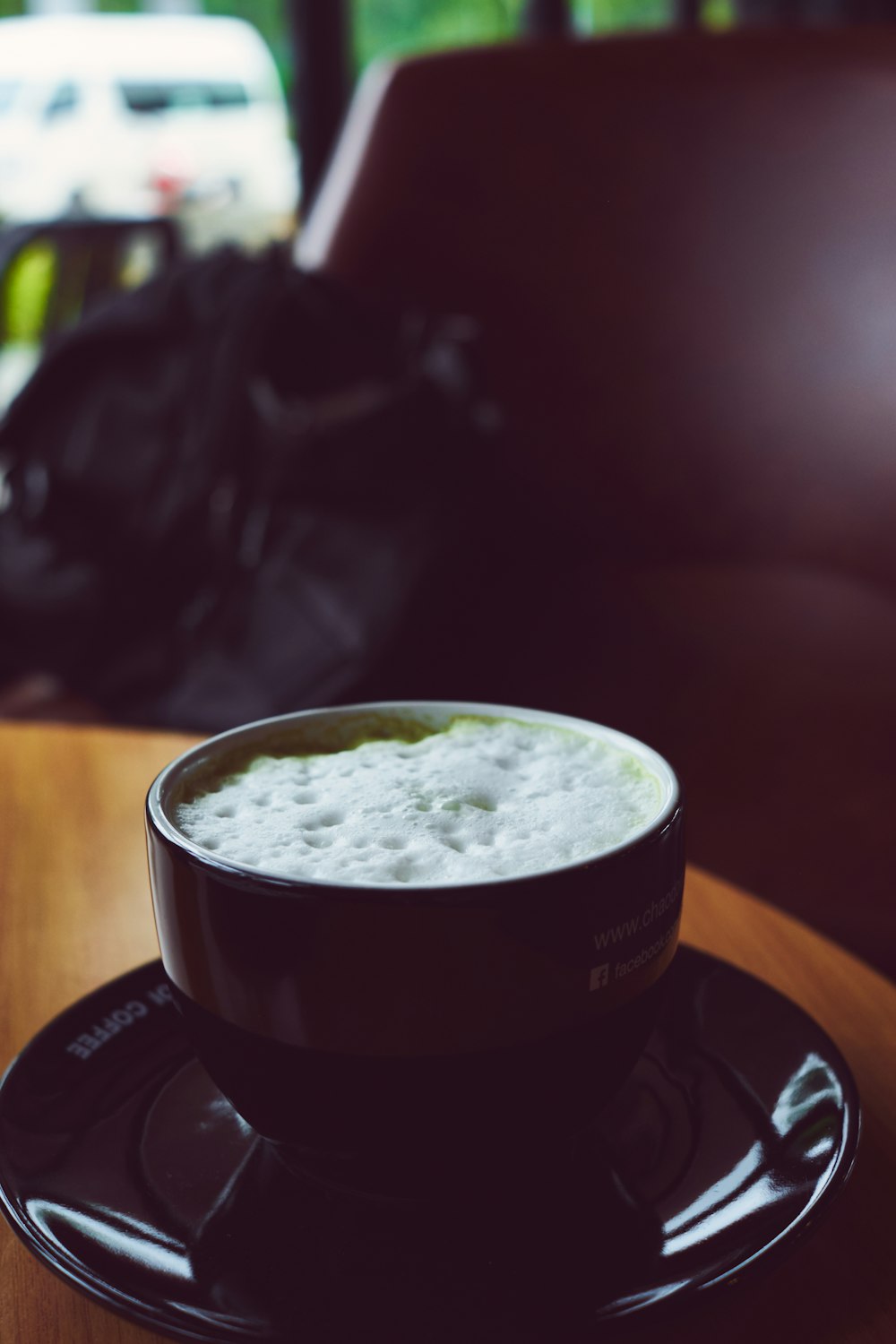 a cup of beer sitting on top of a saucer