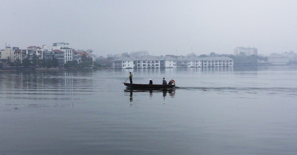 person standing on black boat during daytime