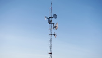 Satellite communication dish against a clear blue sky.