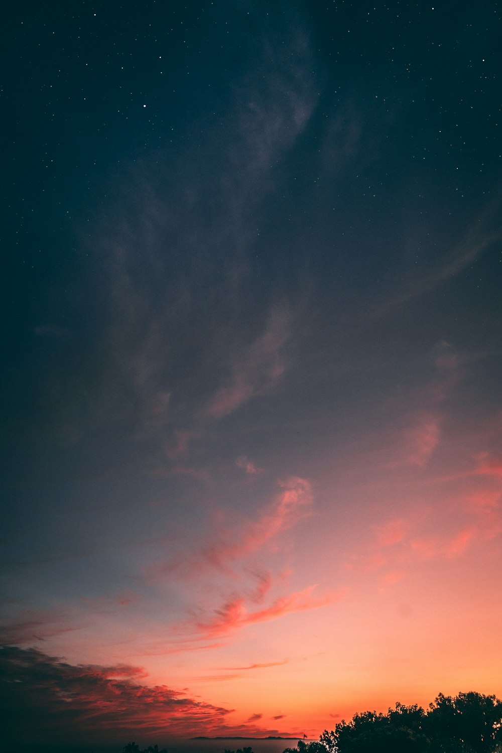 a red and blue sky with a few clouds