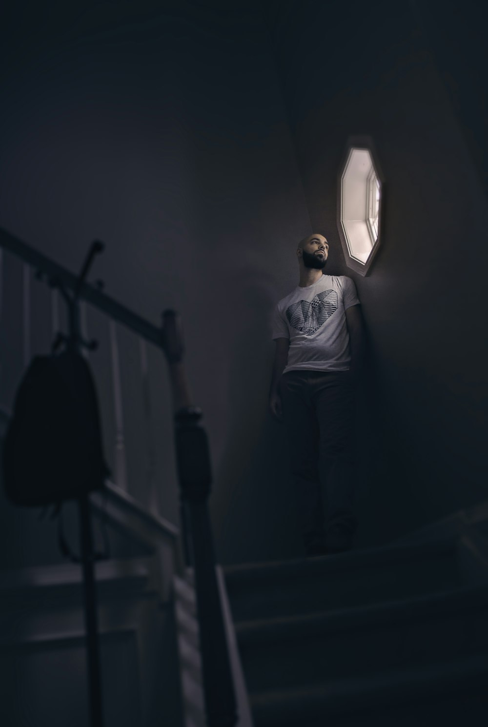 man leaning on wall while looking outside