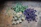 Close-up of fresh moringa leaves and hibiscus flowers arranged on a rustic wooden table.
