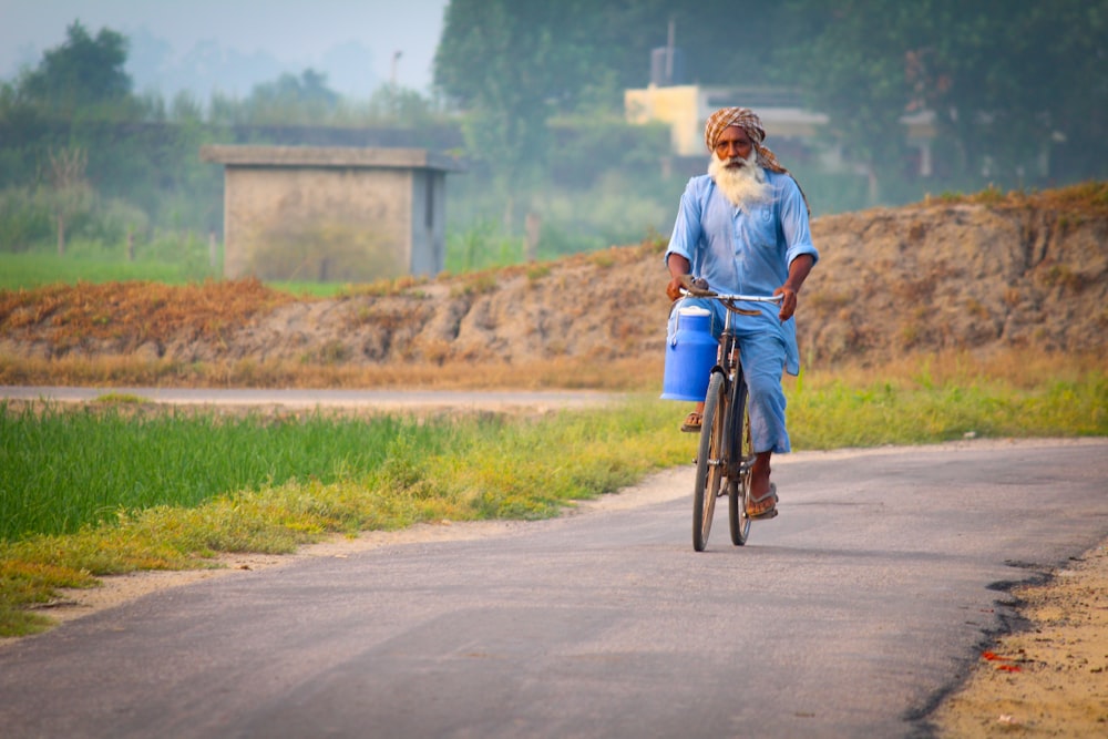 old man biking on concrete road during daytime
