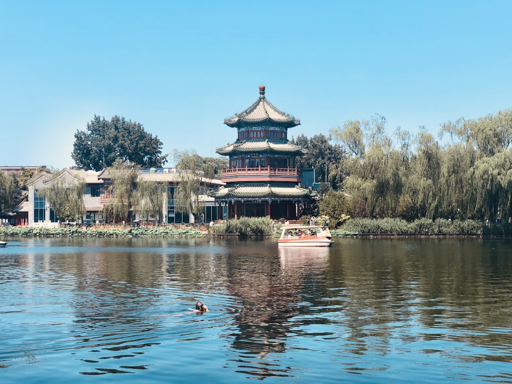 boat on body of water near temple during day