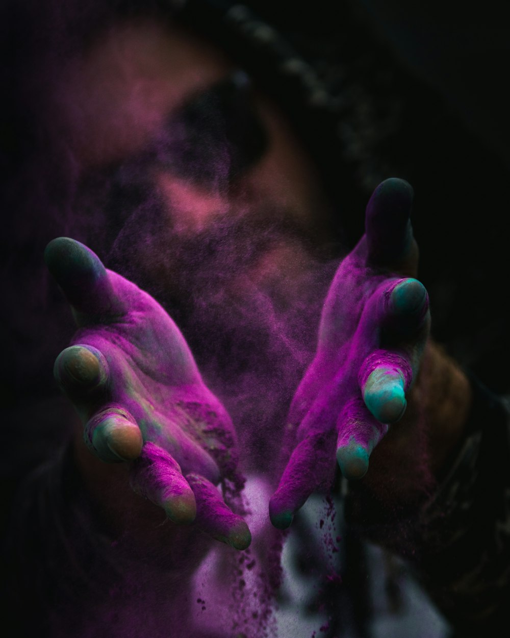 a person with their hands covered in colored powder