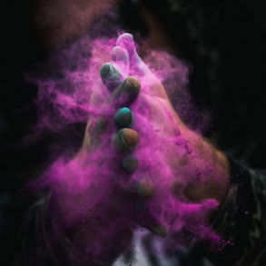 person with colored powders on hands
