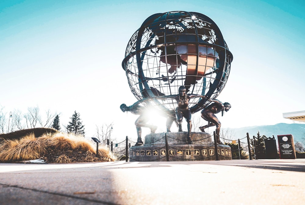 Hommes portant une statue de globe pendant la journée