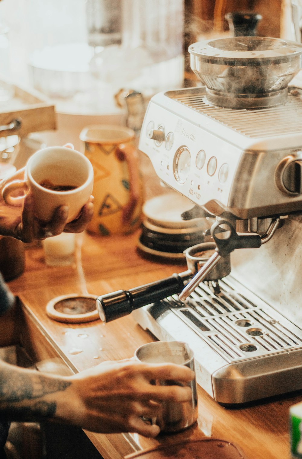 a person pouring a cup of coffee from a coffee maker