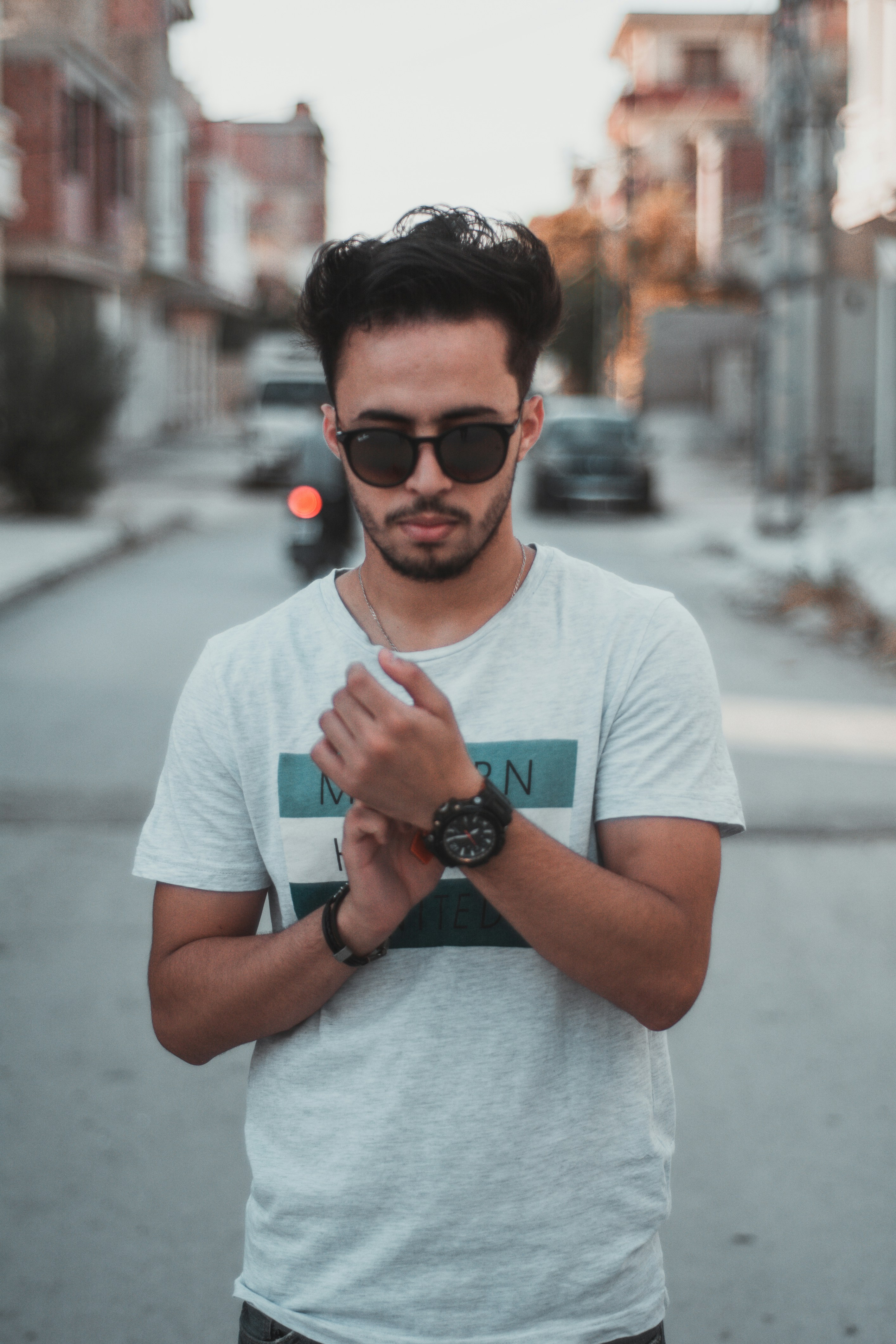 黒い時計を持っている白いクルーネックのシャツを着た男の写真 Unsplashで見つけるグレーの無料写真