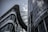 Modern architecture featuring two large glass and steel buildings with sleek, curved designs under a cloudy sky.