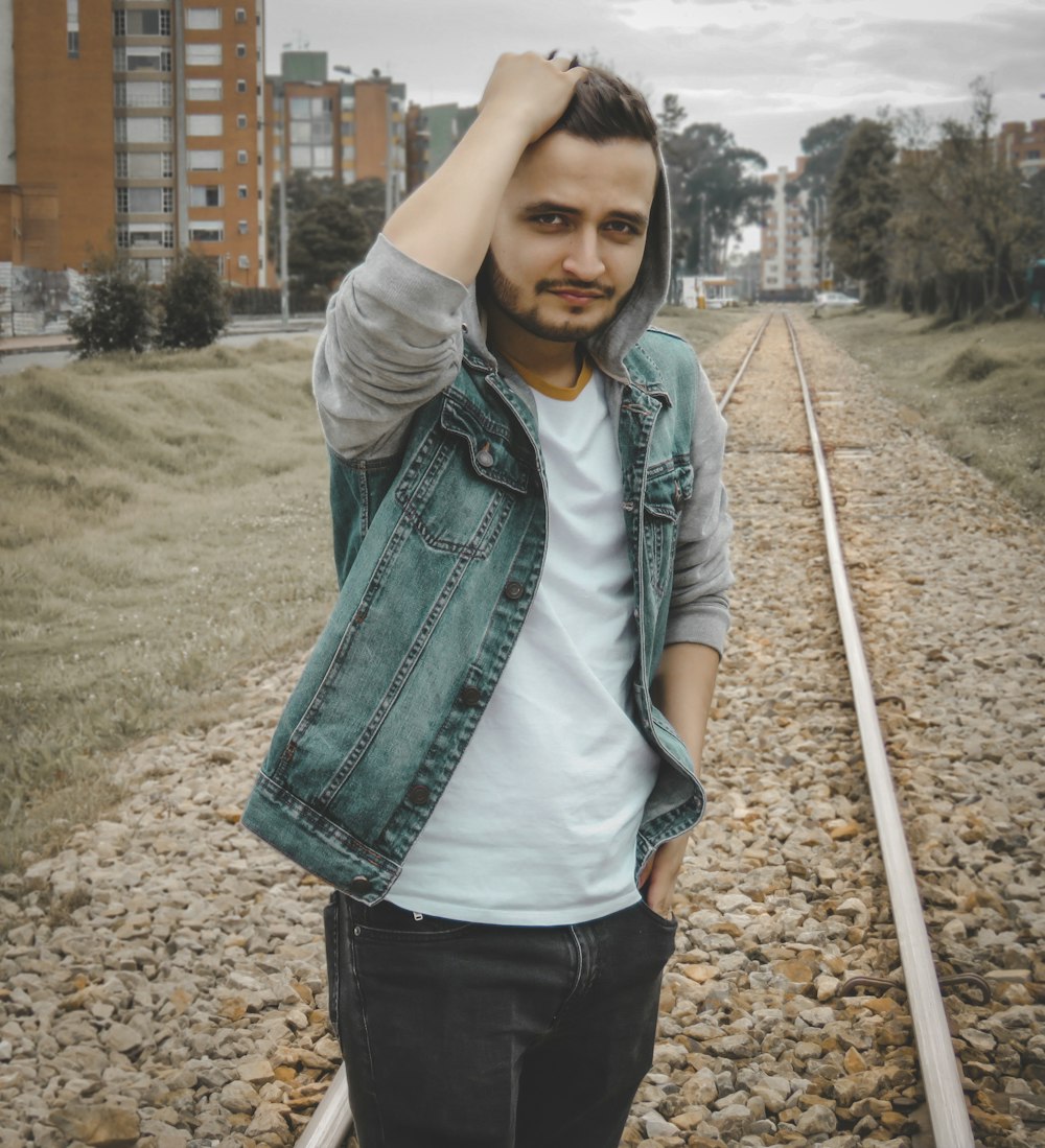 Un hombre se para en el ferrocarril durante el día