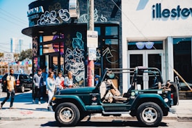 green Jeep Wrangler SUV on road during daytime
