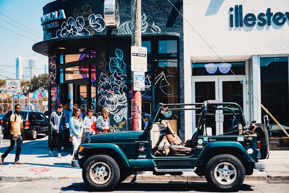 green Jeep Wrangler SUV on road during daytime