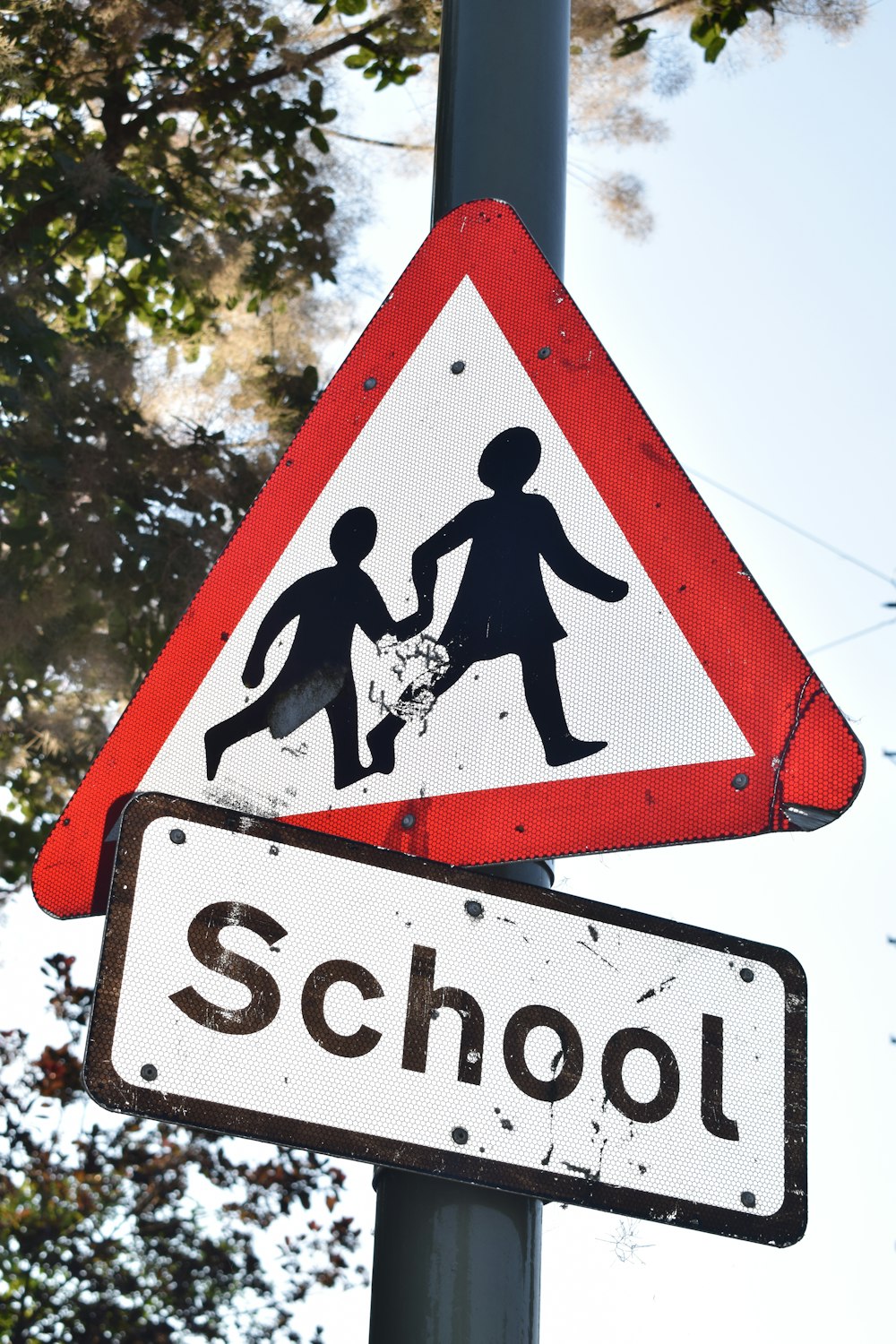 ein rot-weißes Schild mit der Aufschrift "Schule" und ein schwarz-weißes Schild mit der Aufschrift "Schule"