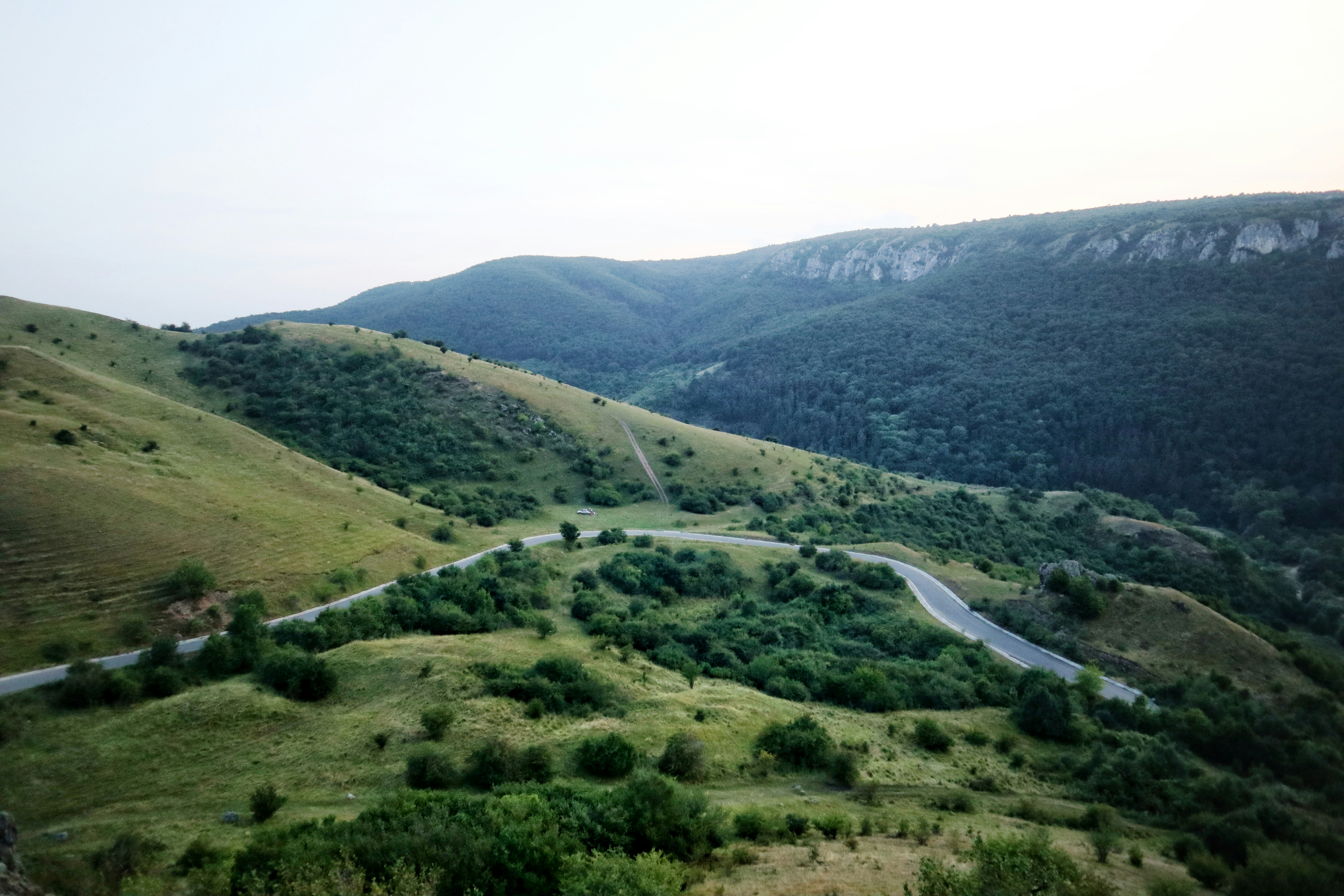 a winding road winding through a lush green valley