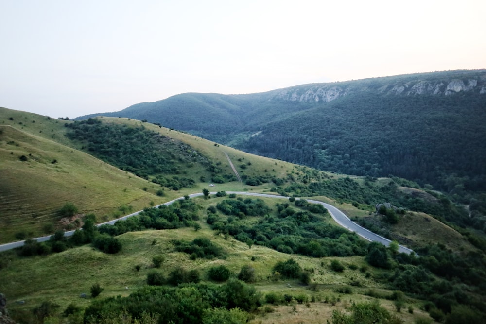 Une route sinueuse serpentant à travers une vallée verdoyante