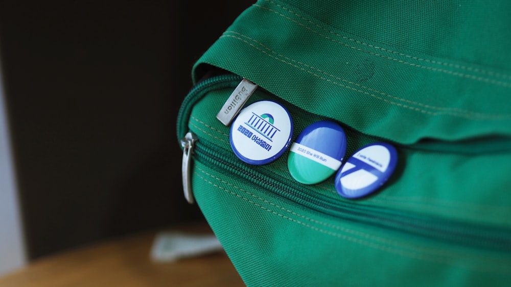 green badges on bag