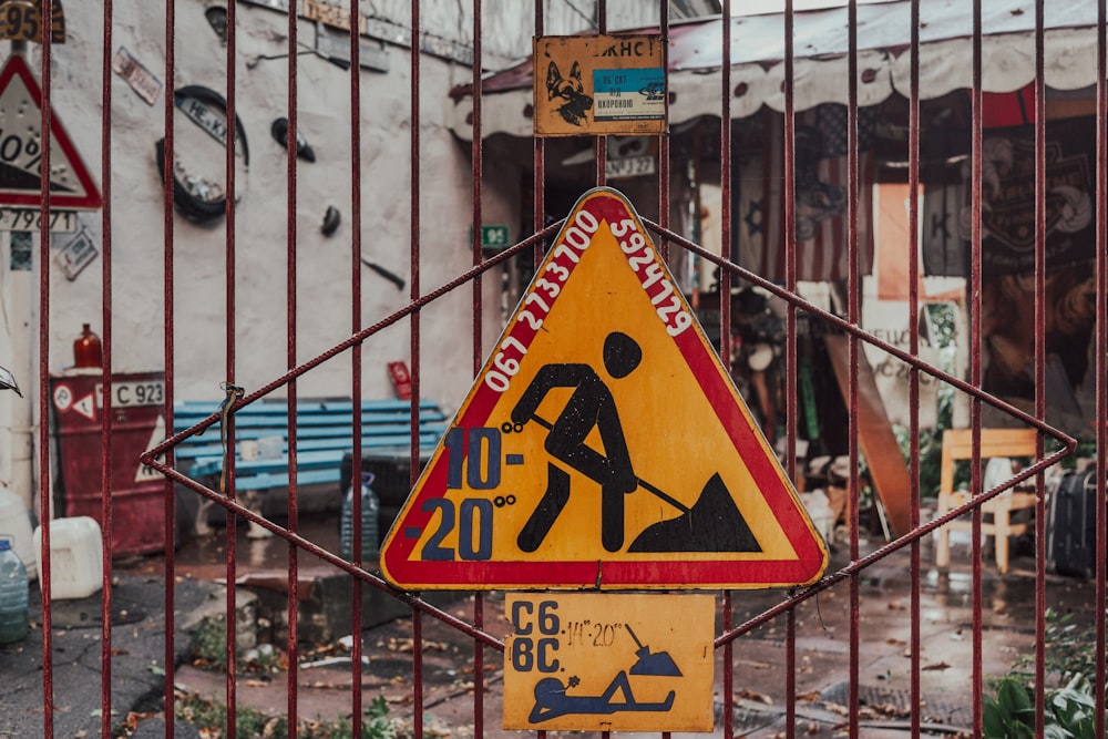 men at work sign mounted on closed gate