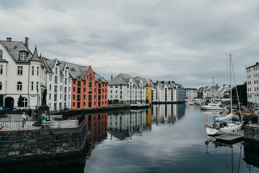 boats beside white and brown buildings during daytime