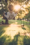A close-up of a smiling child playing in a sunlit park.
