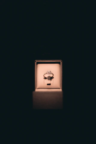 Close-up of a master jeweler delicately setting a sparkling diamond into a gold ring under soft lighting.