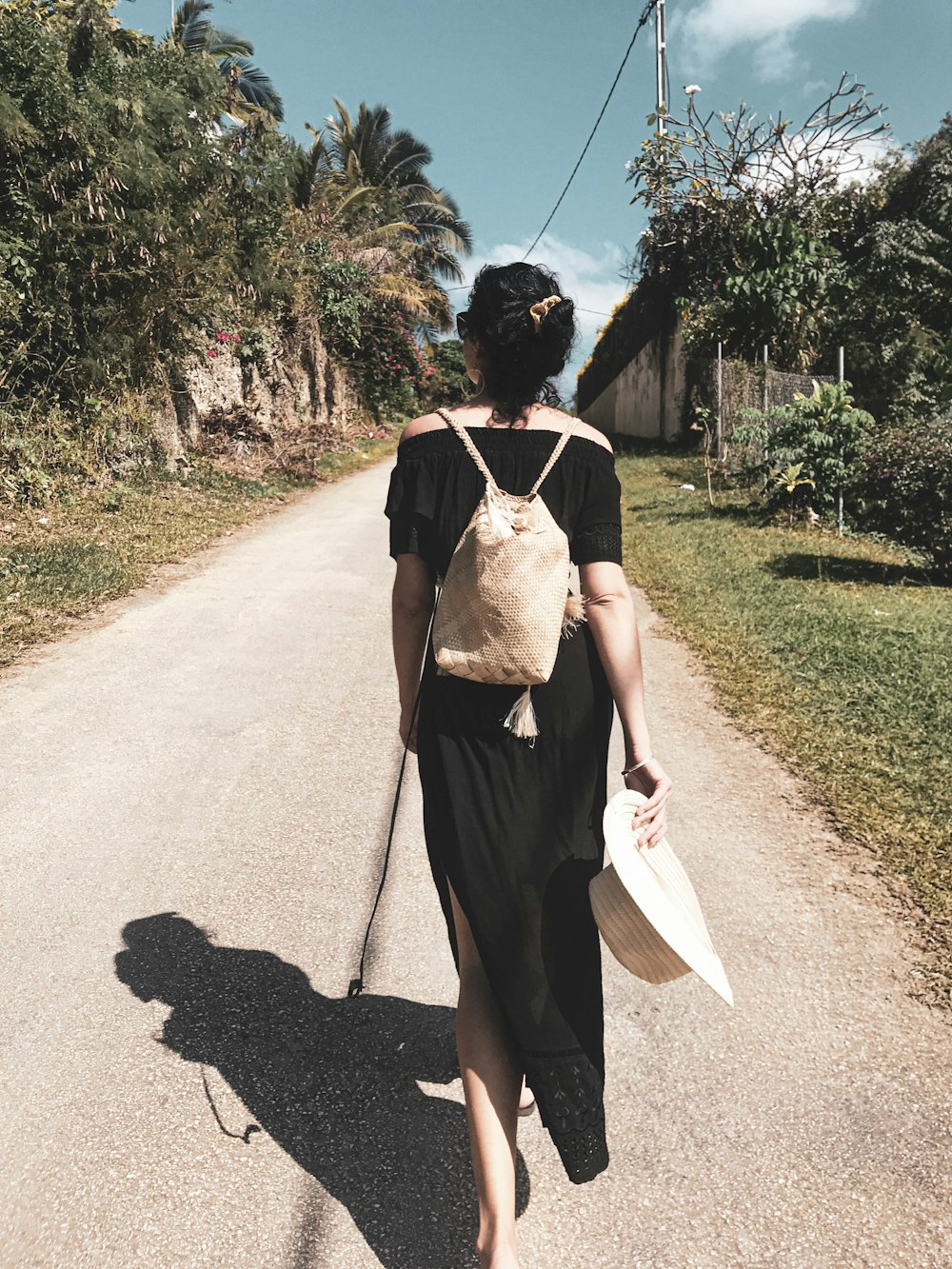 woman walking on pathway near trees