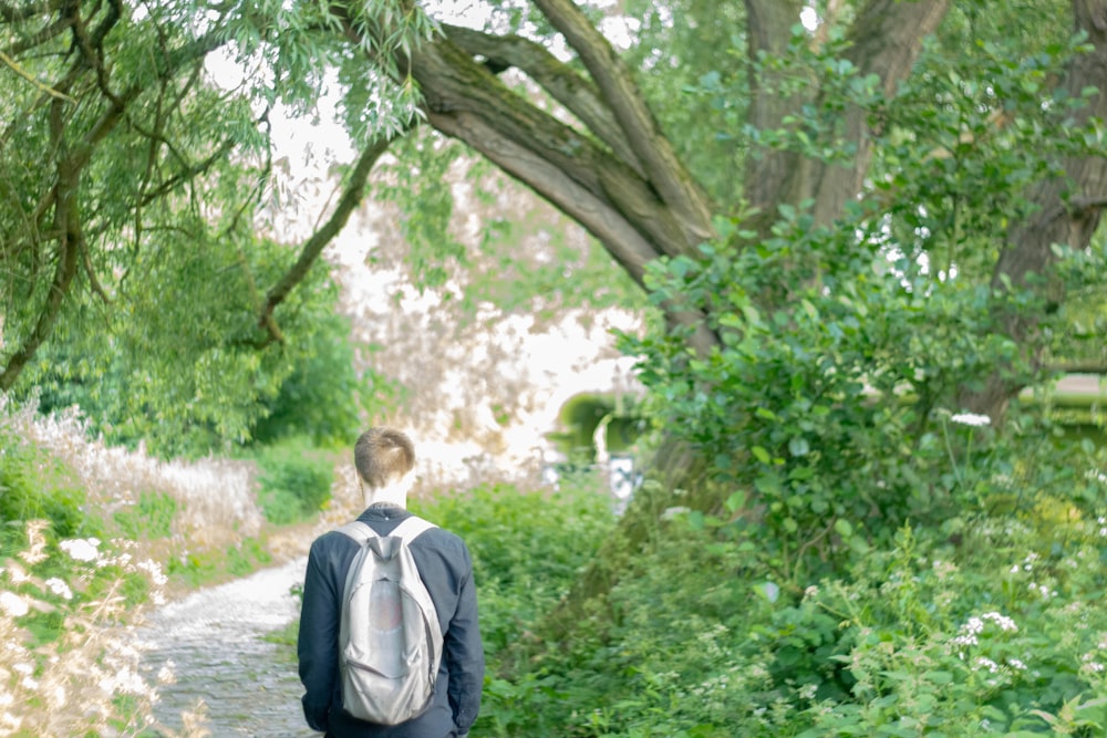 man walking beside tree