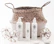 A woven basket with handles holds three cylindrical skincare product bottles labeled ONNE, which include a pump bottle, a spray bottle, and a smaller cream bottle. Around the basket are two decorative spherical ornaments made of glass and twine, and some smooth stones.