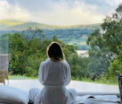 sitting woman in white robe looking at mountains during daytime
