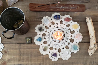 A serene flat lay of colorful crystals, candles, and tarot cards arranged on a wooden table.